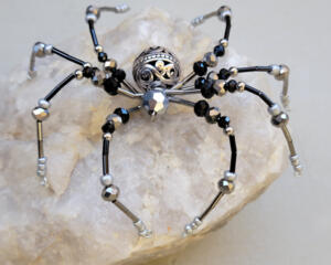 Handmade black and silver beaded spider ornament with iridescent accents and detailed wire legs, crafted by Beneath the Oak Designs.